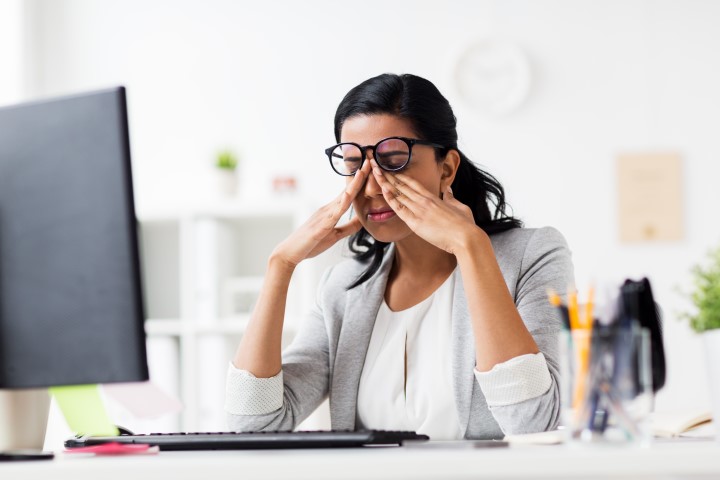 business, overwork, deadline, vision and people concept - tired businesswoman in glasses working at office and rubbing eyes